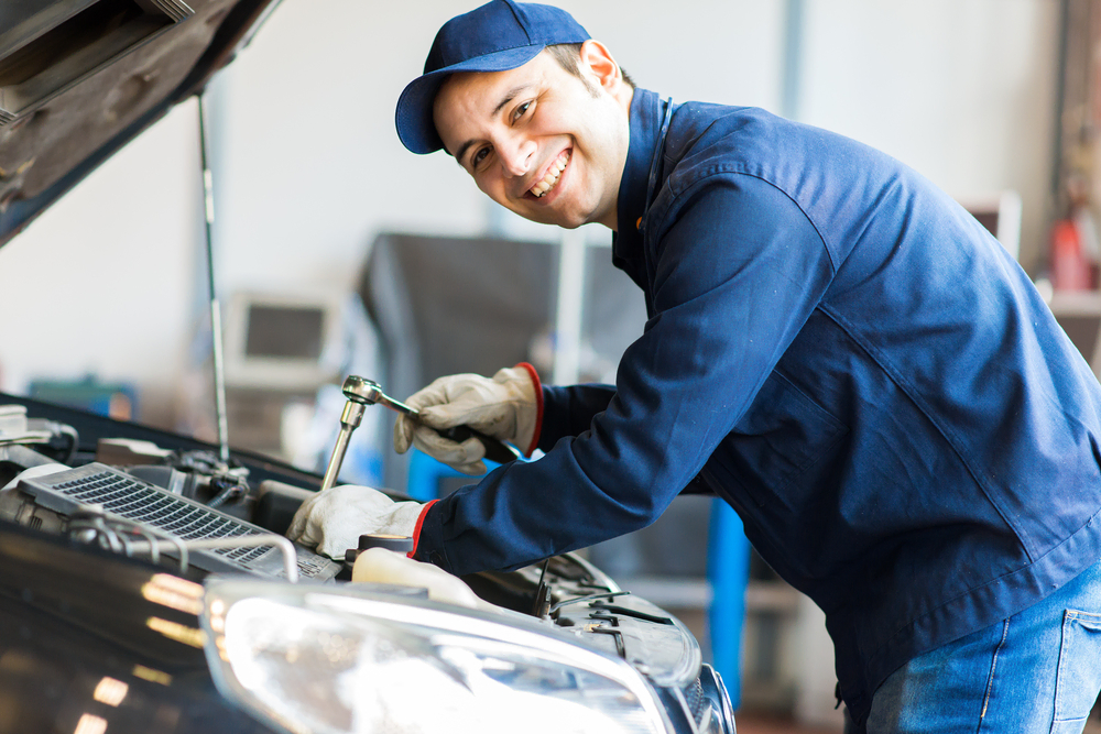 Smiling mechanic works under the hood