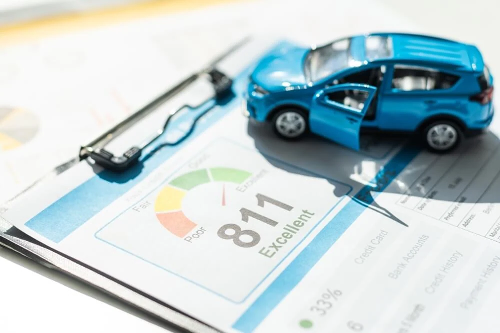 Blue toy car on a credit score document - Cheap car insurance in Georgia