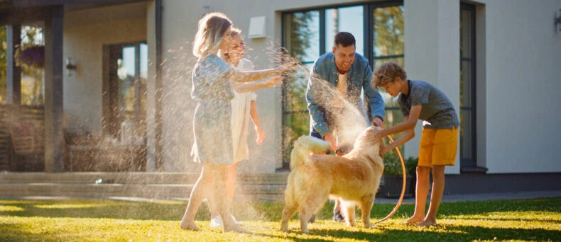 Family playing and enjoying the summer while getting wet with hose water