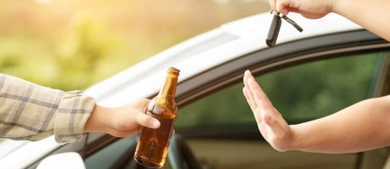 Man holding a beer in one hand and refusing to hand over car keys to a drunk driver - Southern Harvest Cheap auto insurance in Georgia.