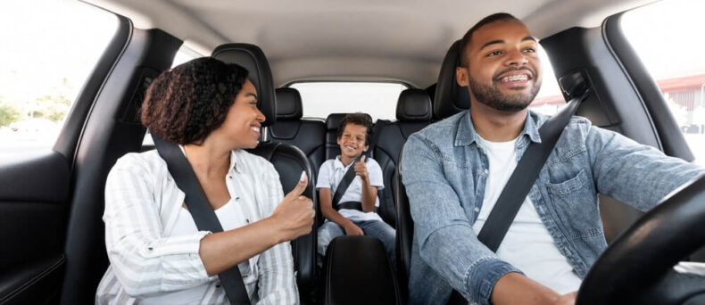 Family riding in car, mom and dad up front and baby in car seat in the rear - cheap car insurance in Georgia.